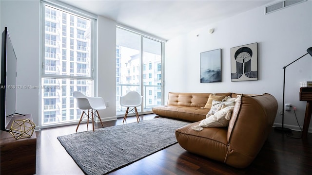 living room featuring dark hardwood / wood-style floors, expansive windows, and plenty of natural light