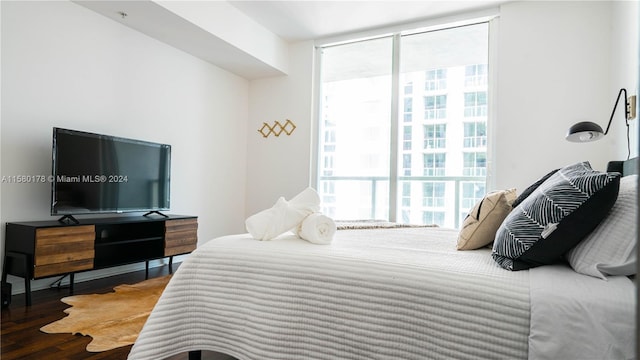 bedroom featuring expansive windows and hardwood / wood-style flooring