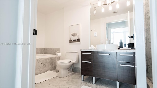 bathroom featuring oversized vanity, tile floors, toilet, and tiled bath