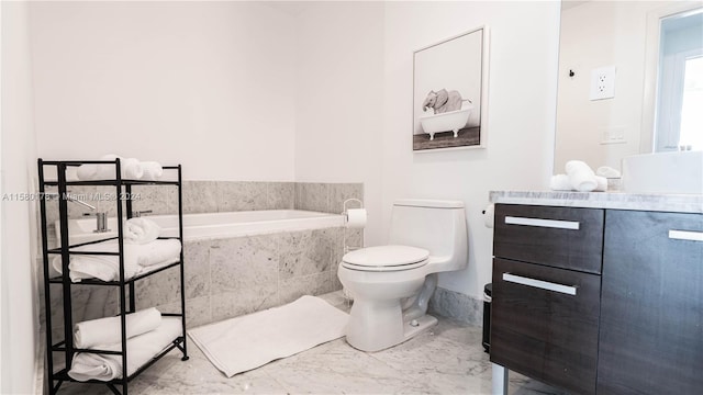 bathroom featuring vanity, tile floors, toilet, and tiled tub