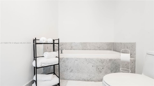 bathroom featuring toilet, tiled tub, and tile flooring