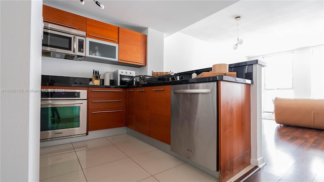 kitchen featuring stainless steel appliances, light hardwood / wood-style floors, and kitchen peninsula