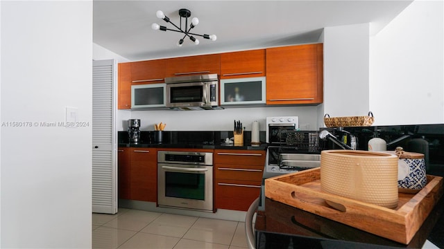 kitchen featuring sink, a notable chandelier, stainless steel appliances, and light tile floors