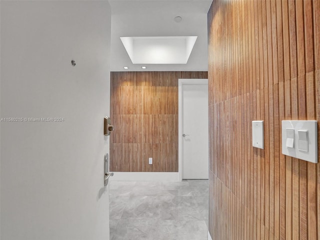 hallway featuring wood walls and tile floors