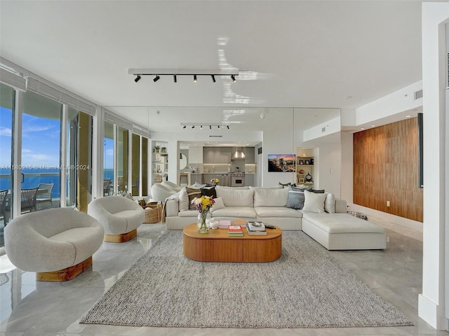 living room featuring a water view, expansive windows, and track lighting