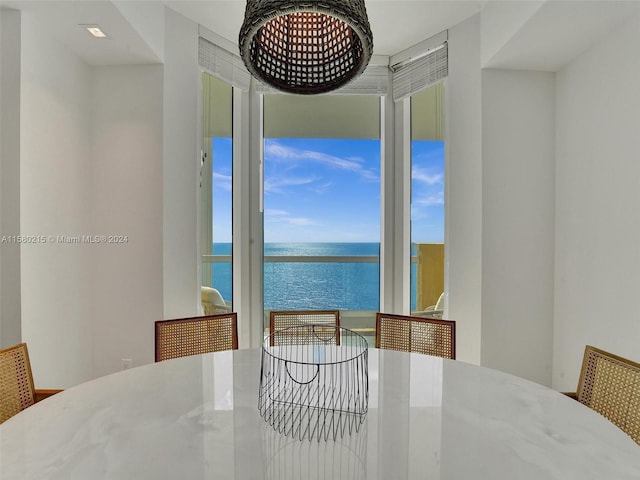 dining room featuring floor to ceiling windows and a water view