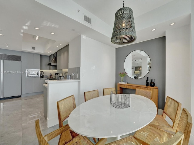 dining space with light tile floors and a tray ceiling