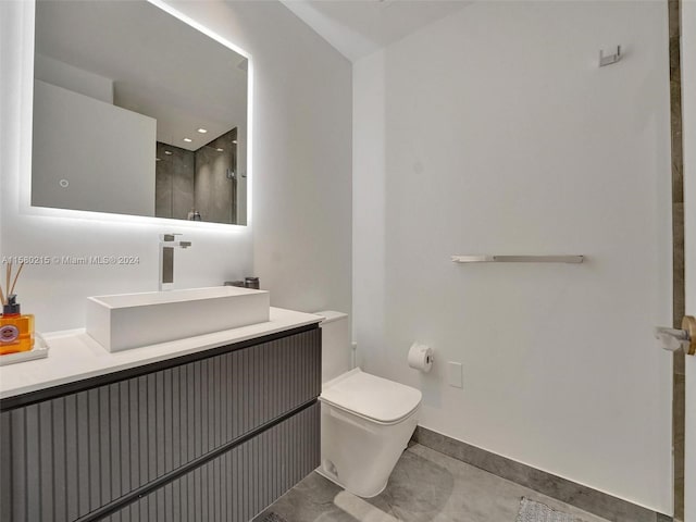 bathroom with tile flooring, vanity, and toilet