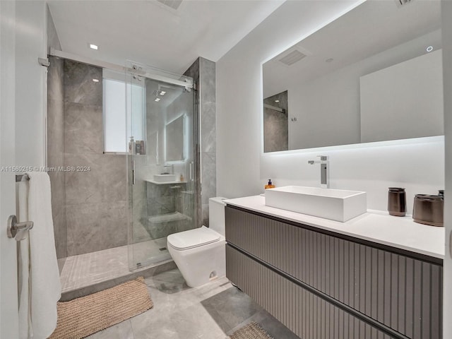 bathroom featuring a shower with door, vanity, toilet, and tile flooring