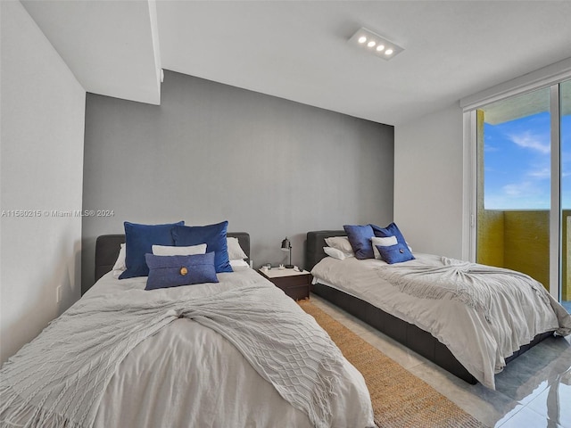 tiled bedroom featuring a wall of windows