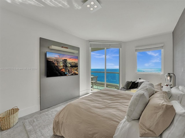 bedroom with a water view and access to exterior