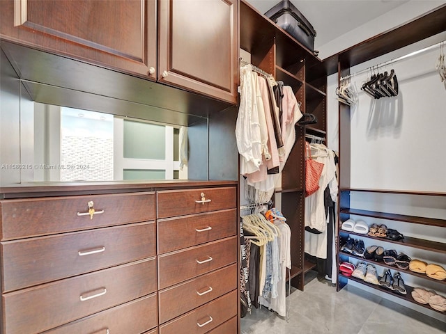 walk in closet with light tile floors