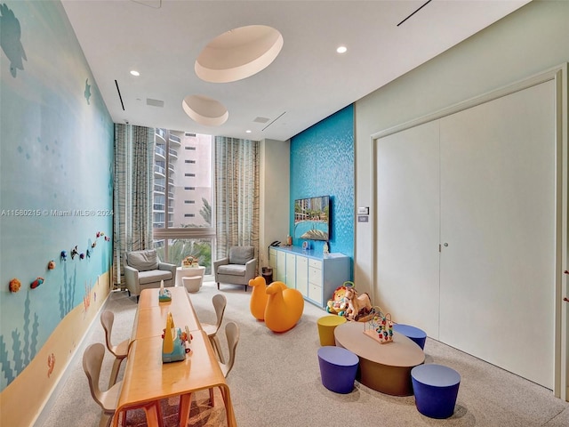 recreation room with expansive windows and carpet flooring