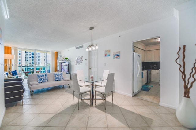 dining space with an inviting chandelier, a wall of windows, light tile flooring, and a textured ceiling