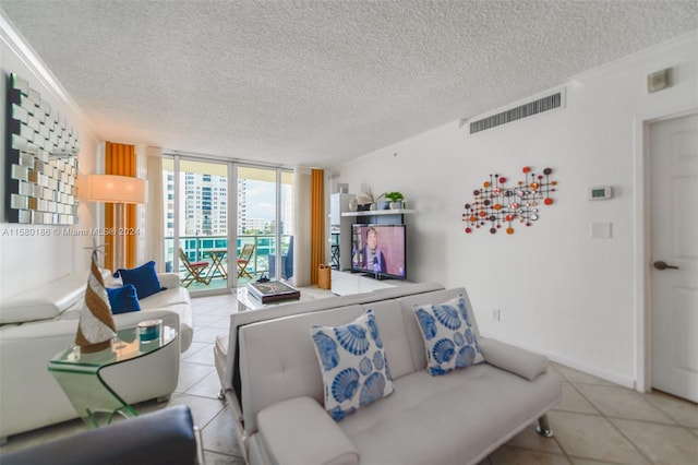 living room with floor to ceiling windows, light tile floors, and a textured ceiling