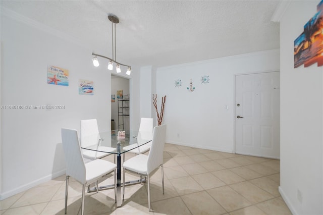 dining area featuring ornamental molding, light tile flooring, track lighting, and a textured ceiling