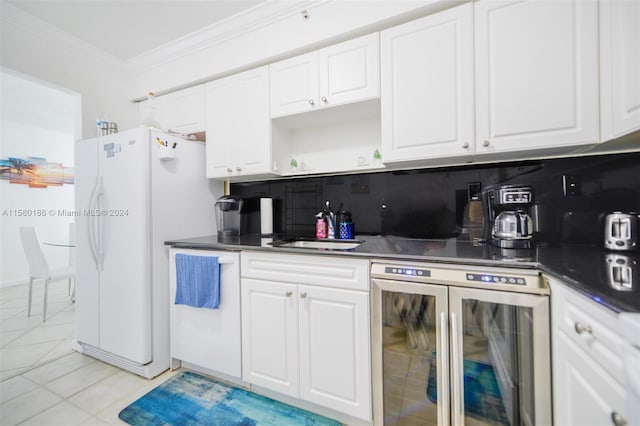 kitchen featuring beverage cooler, crown molding, white cabinetry, light tile floors, and tasteful backsplash