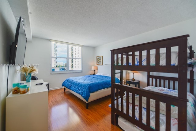 bedroom featuring hardwood / wood-style flooring and a textured ceiling