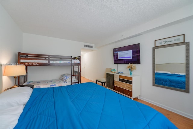 bedroom with wood-type flooring and a textured ceiling