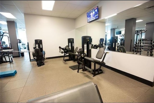 workout area with a drop ceiling and tile flooring