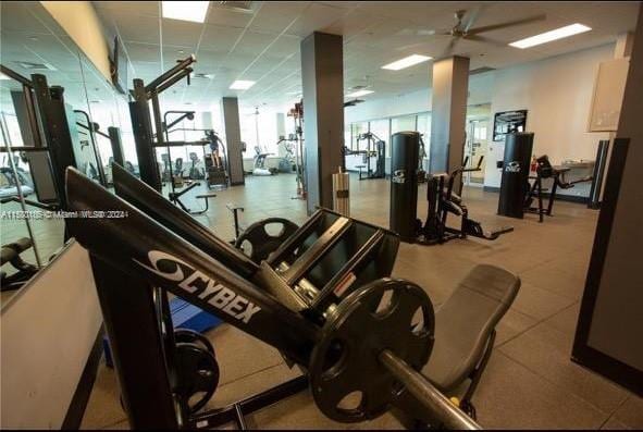 gym with ceiling fan and a paneled ceiling