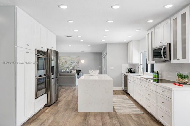 kitchen featuring light hardwood / wood-style floors, white cabinetry, sink, and stainless steel appliances