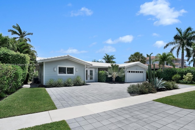 single story home with a garage and a front lawn