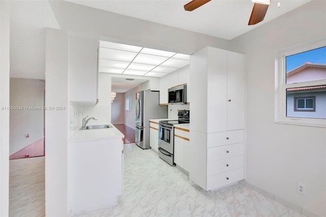 kitchen with ceiling fan, a sink, white cabinetry, light countertops, and appliances with stainless steel finishes