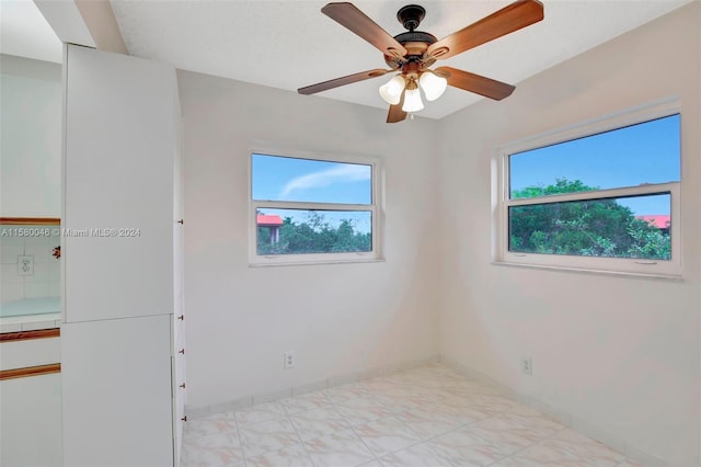 unfurnished room with light floors, plenty of natural light, and baseboards