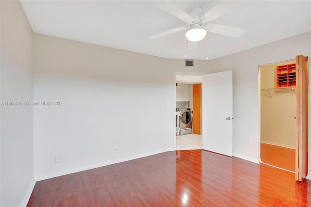 unfurnished bedroom with washer / dryer, visible vents, baseboards, and wood finished floors