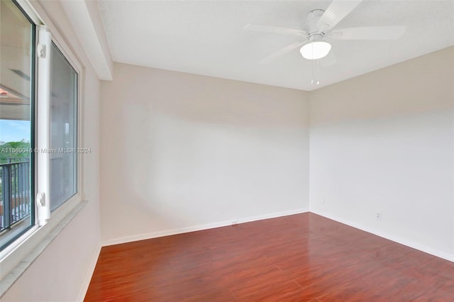 unfurnished room with ceiling fan, wood finished floors, and baseboards