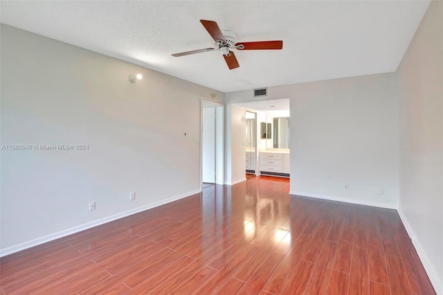 spare room featuring ceiling fan, wood finished floors, visible vents, and baseboards