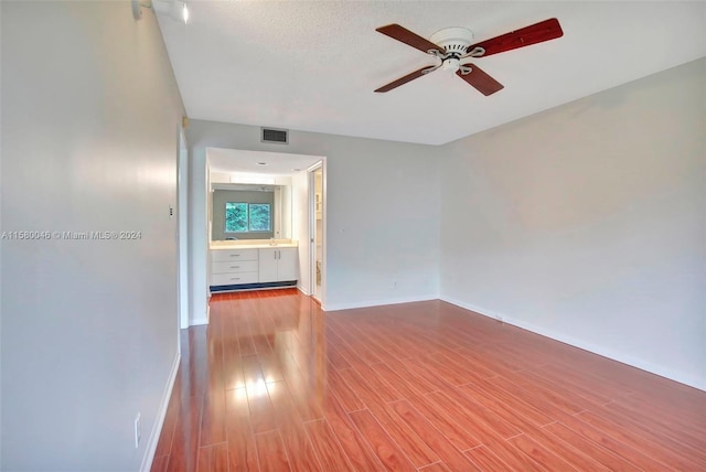 spare room featuring a ceiling fan, baseboards, visible vents, and wood finished floors