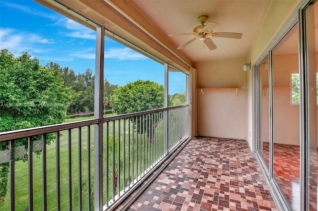 unfurnished sunroom featuring ceiling fan