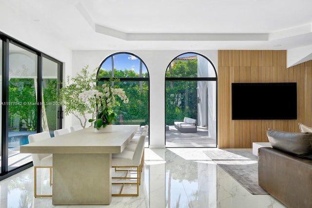 tiled dining area featuring a tray ceiling