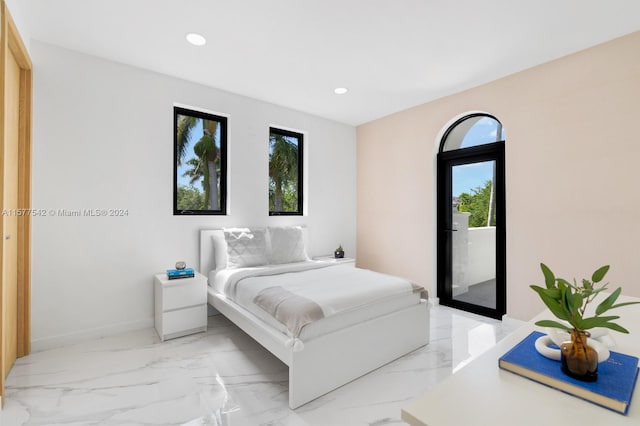 bedroom with light tile floors and access to outside