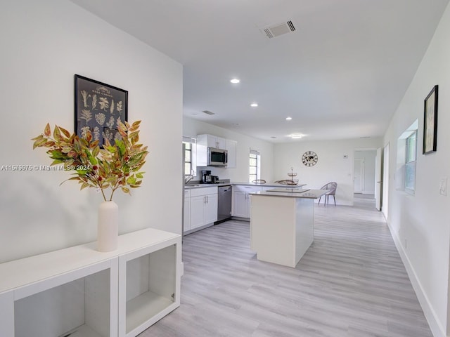 kitchen featuring sink, kitchen peninsula, light hardwood / wood-style floors, and white cabinetry