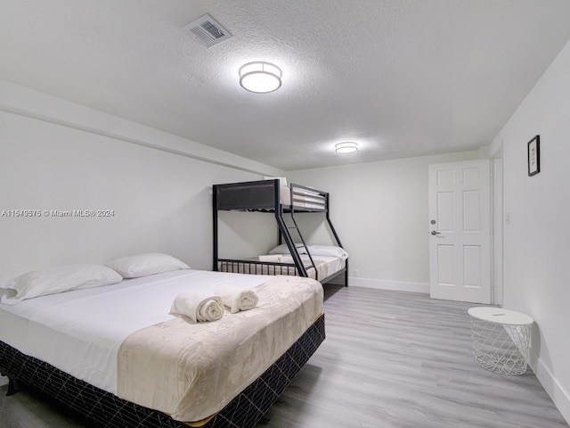 bedroom with a textured ceiling and hardwood / wood-style flooring