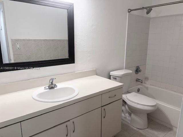 full bathroom featuring tile patterned flooring, vanity, tiled shower / bath combo, and toilet