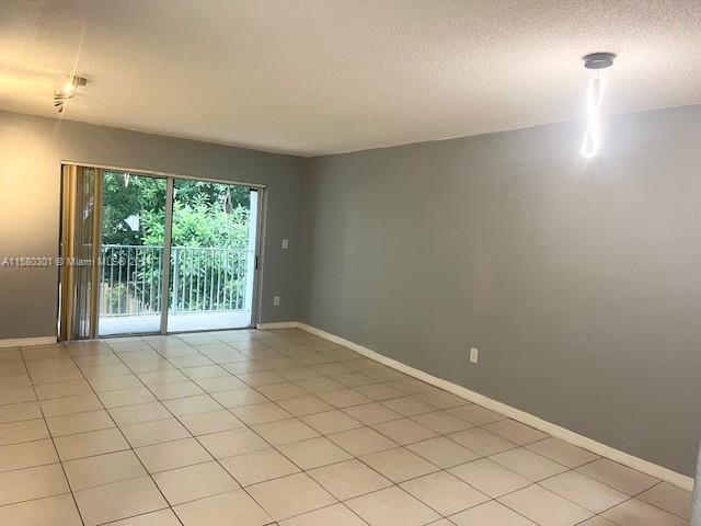 tiled spare room featuring a textured ceiling