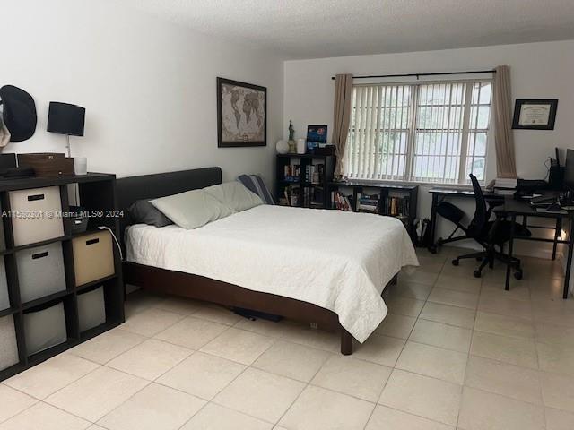 bedroom featuring a textured ceiling and light tile patterned flooring