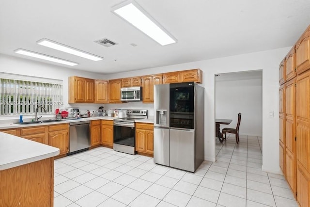 kitchen featuring sink, appliances with stainless steel finishes, and light tile floors