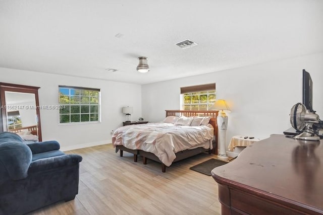 bedroom with light hardwood / wood-style floors and ceiling fan