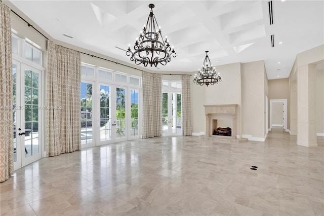 unfurnished living room with french doors, coffered ceiling, a towering ceiling, and a notable chandelier