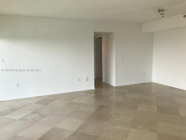 unfurnished room featuring tile flooring and a textured ceiling