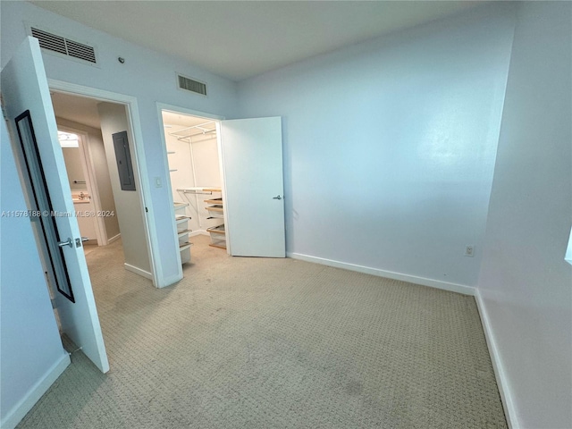 unfurnished bedroom featuring a closet, carpet floors, and a walk in closet