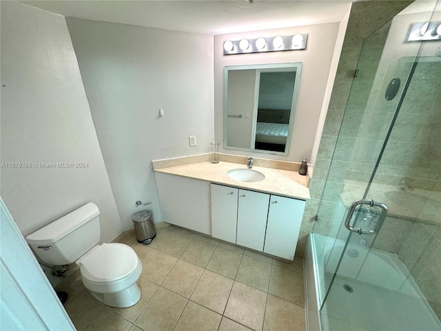 bathroom with toilet, tile floors, and vanity