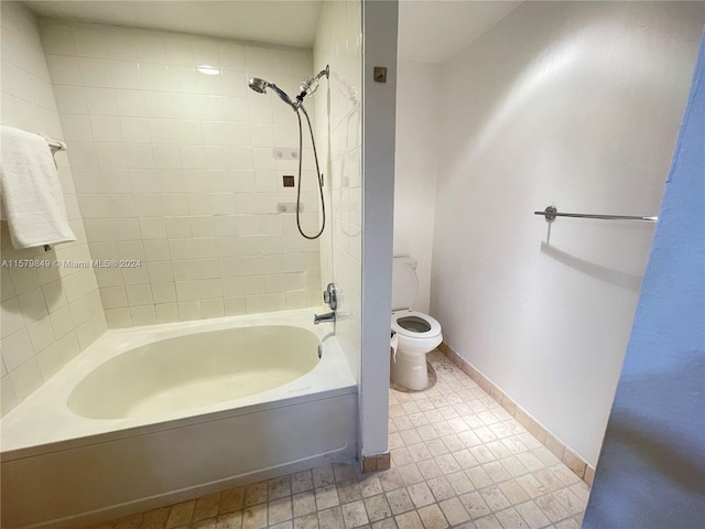 bathroom with tiled shower / bath combo, toilet, and tile flooring