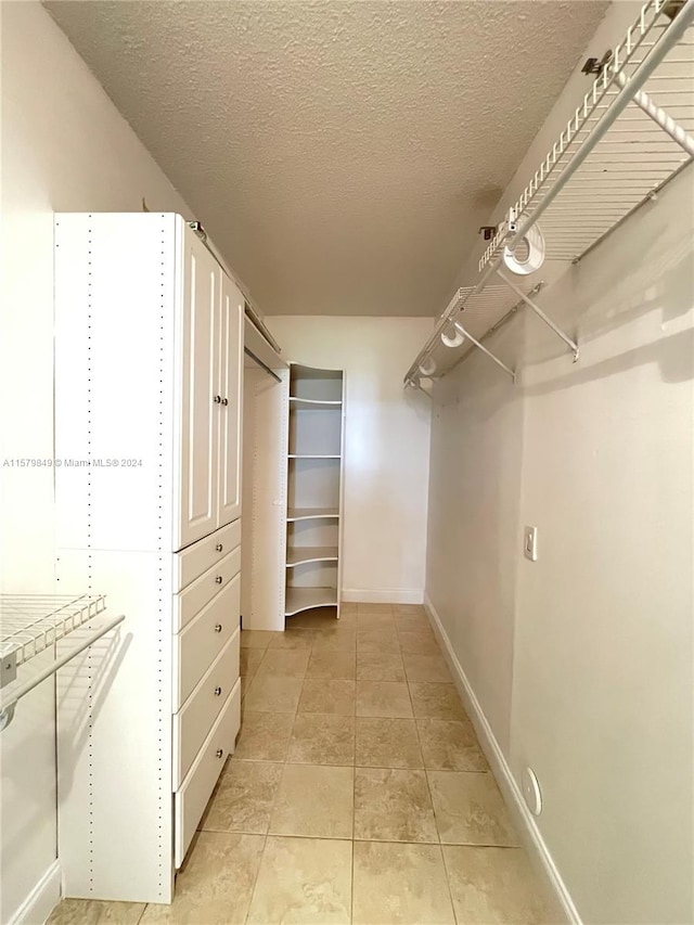 walk in closet featuring light tile floors