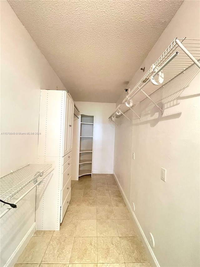 spacious closet with light tile flooring